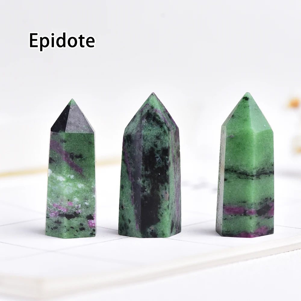 Three green and purple Epidote crystals displayed upright on a white surface.