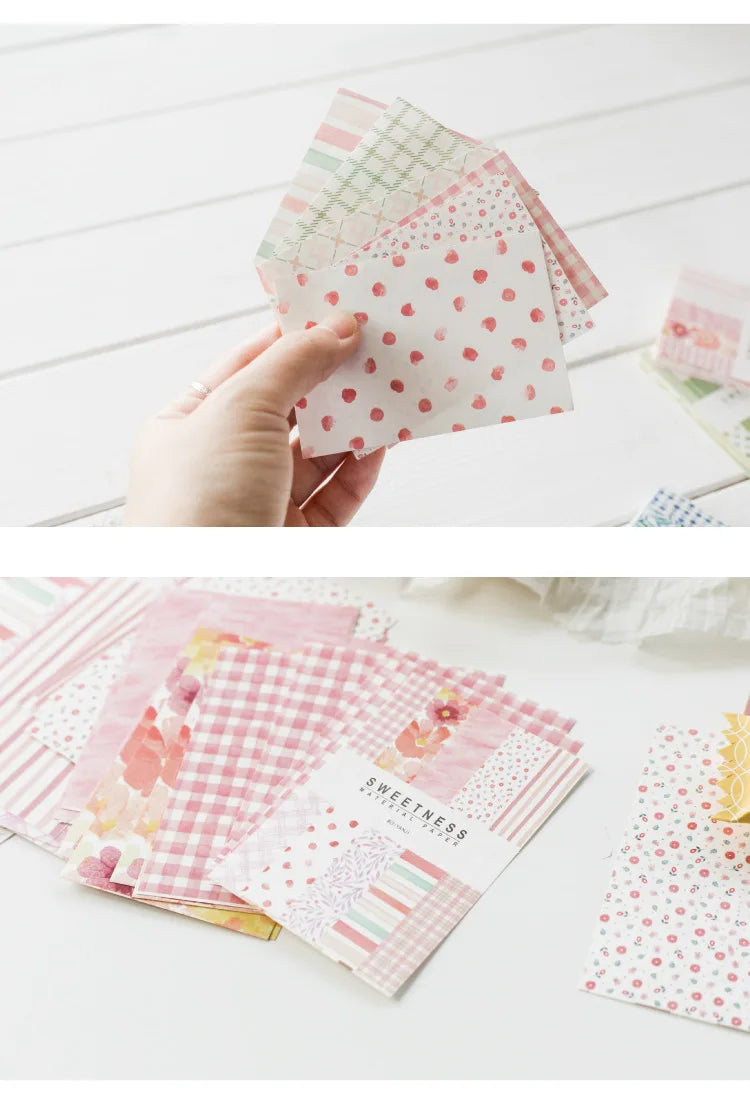 A hand holds a stack of pink and green decorative memo pads and cards for a journal or stationery set.