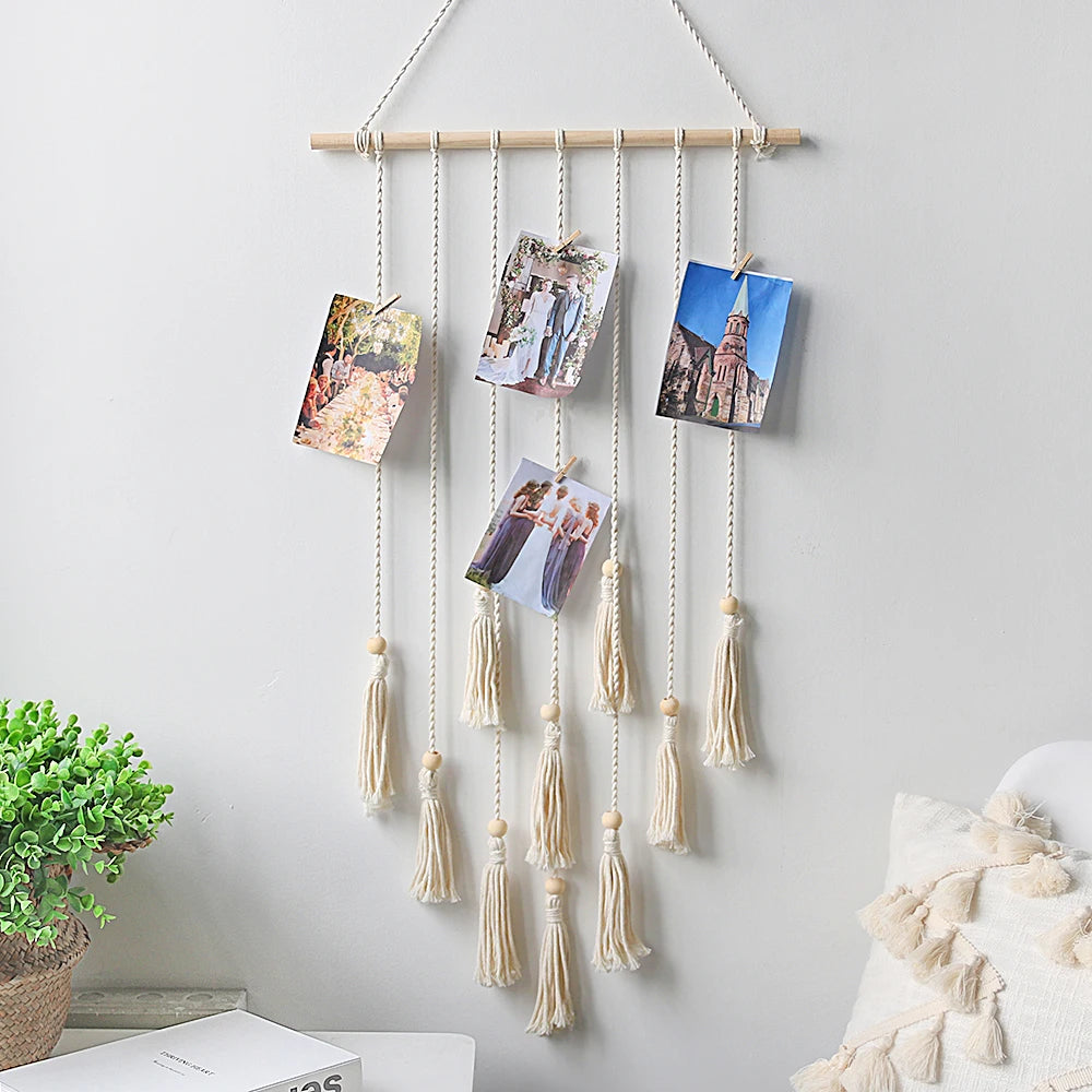 Boho macrame photo display featuring multiple hanging macrame cords with framed photos