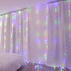 White sheer curtains illuminated by colorful LED string lights in a room setting