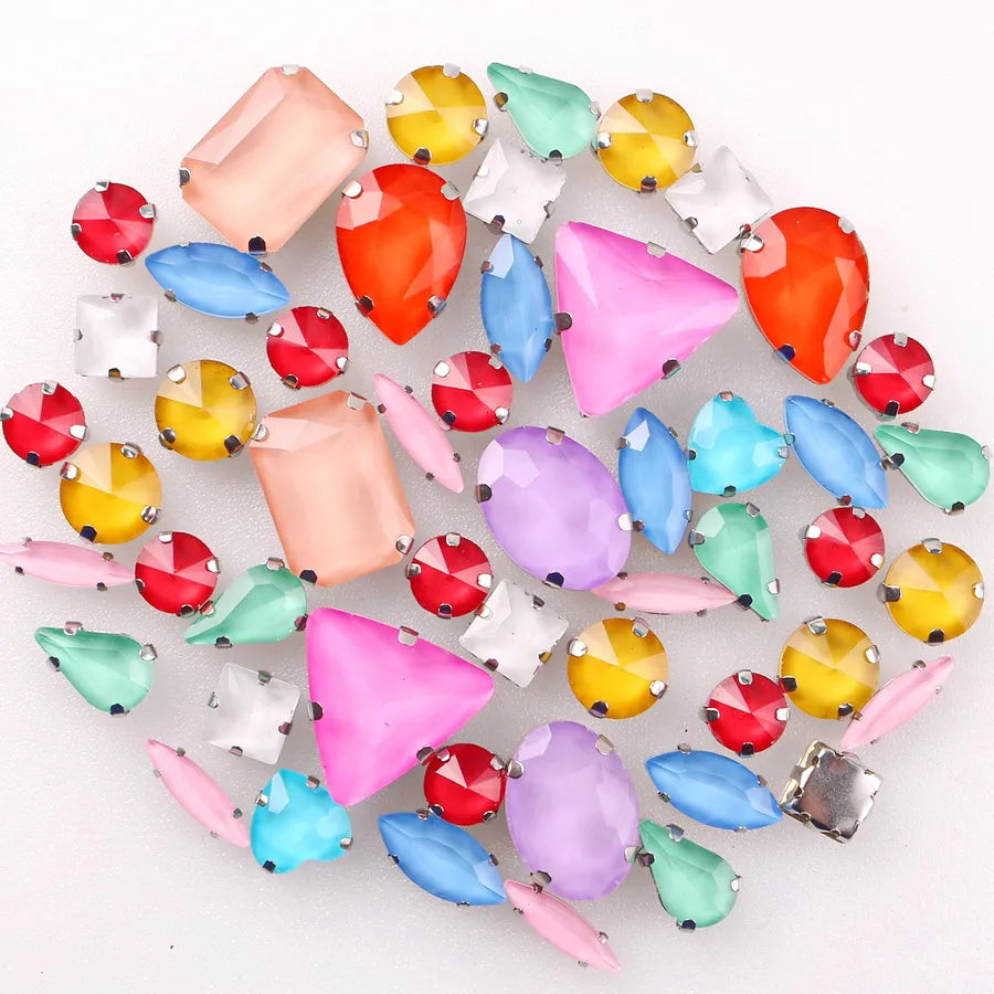 A mix of colorful glass rhinestones in various shades including pink, blue, green, yellow, and red set in silver claws.