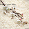 Artificial silk cherry blossom branches with white flowers on a light beige fluffy background