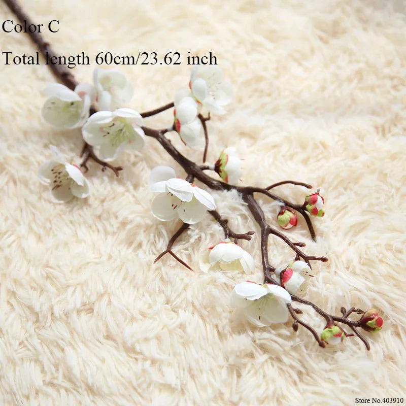 Artificial silk cherry blossom branches with white flowers on a light beige fluffy background