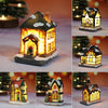 A festive Christmas house night light featuring a warm LED glow and detailed architectural features, set on a snowy base.