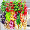 A vibrant display of artificial fruits and vegetables including peppers, tomatoes, cucumbers, and various colorful produce fo