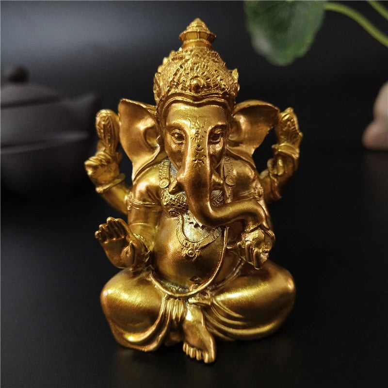 A golden Ganesha statue handcrafted from resin, depicting the deity in a seated posture.