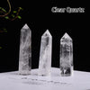 Three clear quartz crystal points of varying sizes displayed on a white surface against a black background.