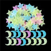A collection of glow-in-the-dark star and crescent moon wall stickers in pastel colors.