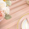 Pink chiffon fabric draped with white roses and green leaves for a wedding arch backdrop