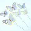 A set of purple and gold butterfly cake toppers on thin sticks for parties and baking