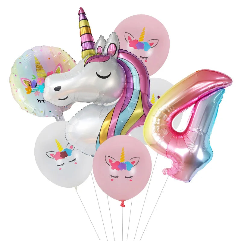 Un ballon en feuille en forme de licorne blanche avec une crinière arc-en-ciel et des ballons roses, jaunes et violets.