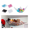 A large mesh toy hammock is shown with various colorful stuffed animals and toys inside, suspended in a room.