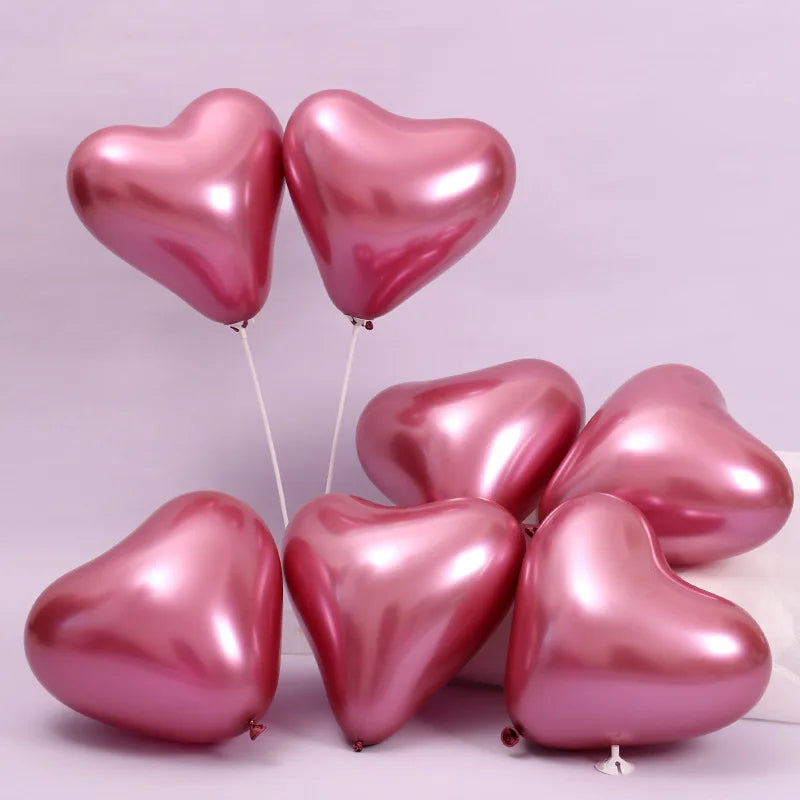 Globos de aluminio en forma de corazón rosa flotando contra un fondo morado claro