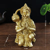 Gold-colored resin statue of Hanuman sitting in a prayer pose for home decor