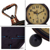 A vintage metal battery alarm clock night light with a brass handle and a round face showing the time.