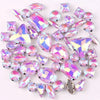 A mix of iridescent silver claw setting glass rhinestones in jelly candy AB colors scattered on a white background.