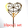 A gold acrylic heart-shaped cake topper with a geometric design on a stick.