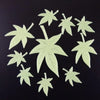 A set of glow-in-the-dark star and moon leaf wall stickers on a dark background.