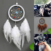 Handmade feather dreamcatcher wall decor with white feathers and colorful beads hanging on a gray wall.