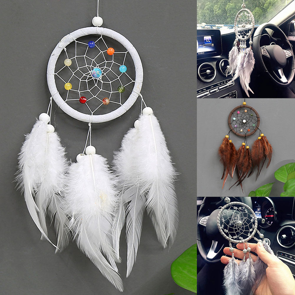 Handmade feather dreamcatcher wall decor with white feathers and colorful beads hanging on a gray wall.