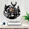 A black silhouette of a deer head and forest trees forms the design of a wall clock.