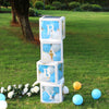 A stack of letter balloon boxes spelling BABY, made of white and blue balloons, placed on green grass.