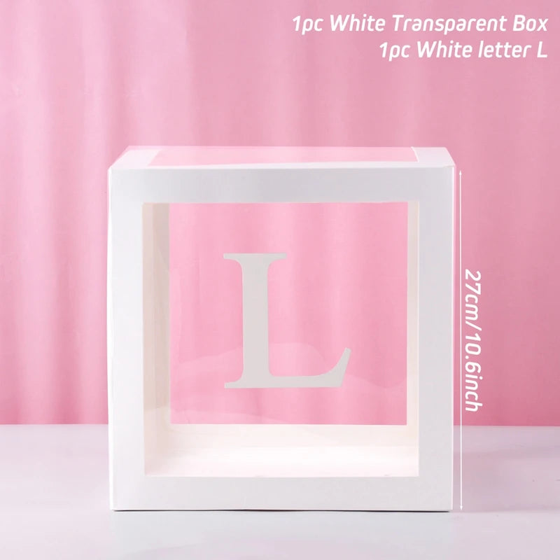A clear white box with a large letter L inside, used for first birthday or baby shower decorations.