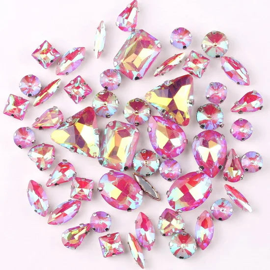 A mix of silver claw setting glass rhinestones in jelly candy AB colors scattered on a white background.