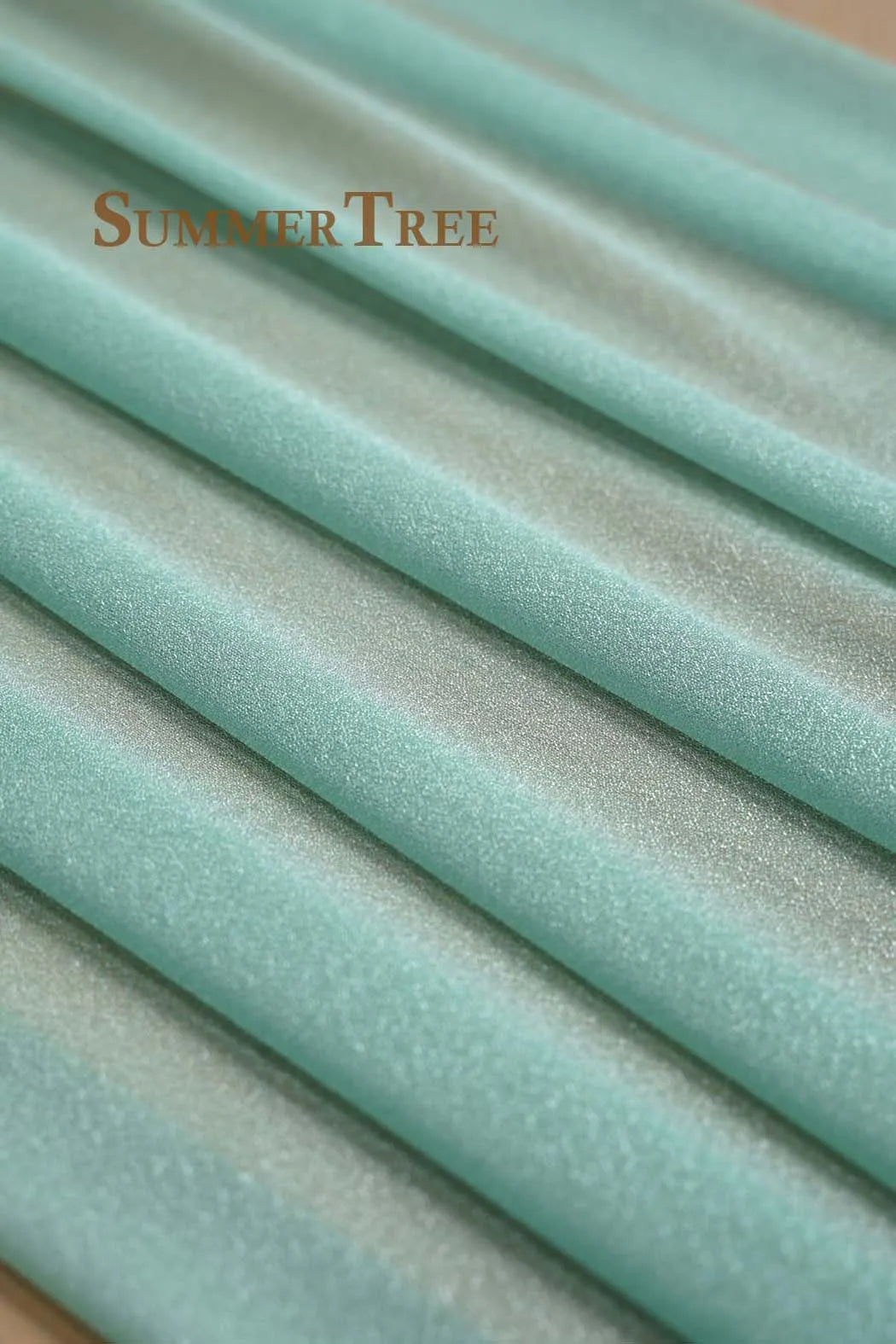Light mint green chiffon fabric draped and folded to show texture