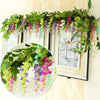 Green and purple silk wisteria garland vine draped across a window frame for home decor