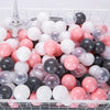 A clear plastic basket filled with a 50-pack of colorful, translucent, and opaque spherical balls in pink, white, and black.