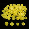 A pile of assorted yellow snap buttons, measuring 12mm and 10.5mm, for crafting.