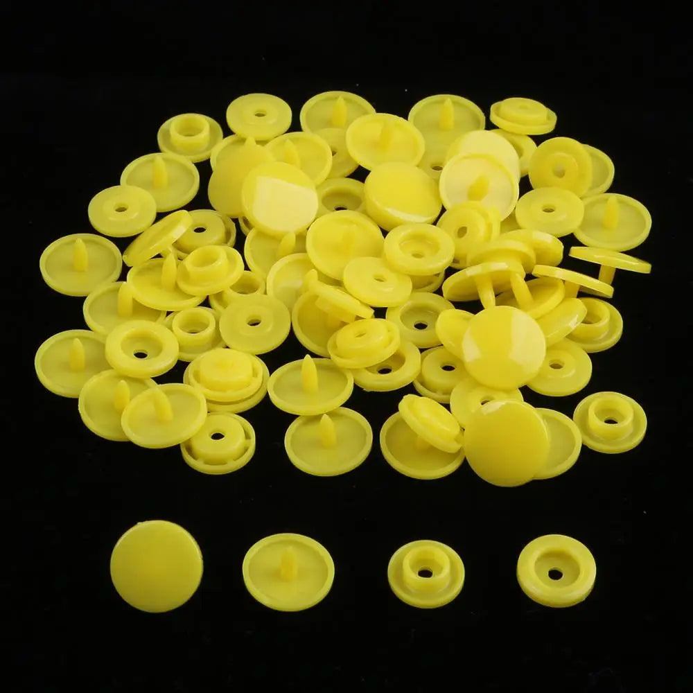 A pile of assorted yellow snap buttons, measuring 12mm and 10.5mm, for crafting.