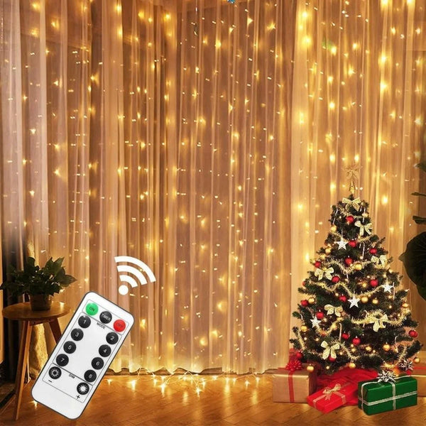 Warm white LED curtain lights with remote control illuminating a Christmas tree and gift box.