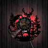A silhouette of a deer head and pine trees forms the face of a rustic wall clock.