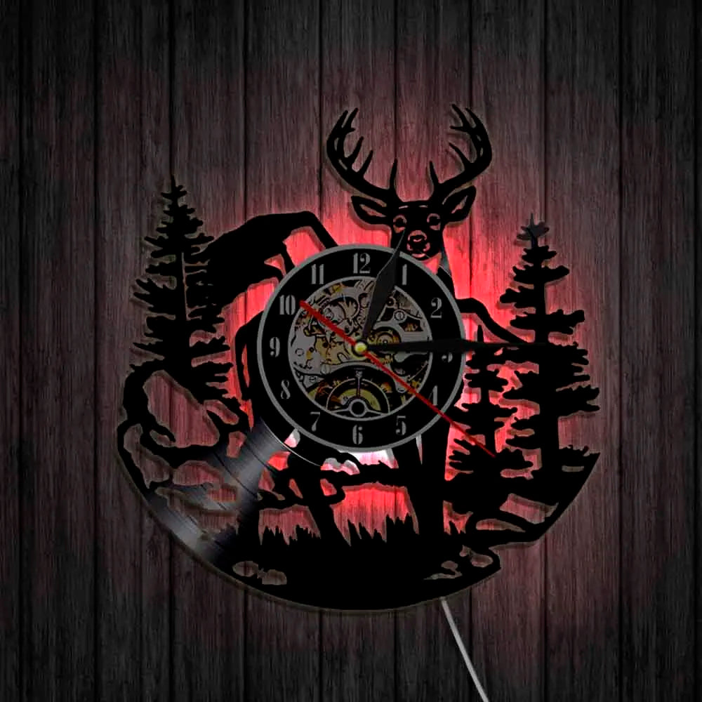 A silhouette of a deer head and pine trees forms the face of a rustic wall clock.