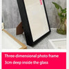 Black three-dimensional photo frame with 3cm deep glass inside, displayed on a light surface.