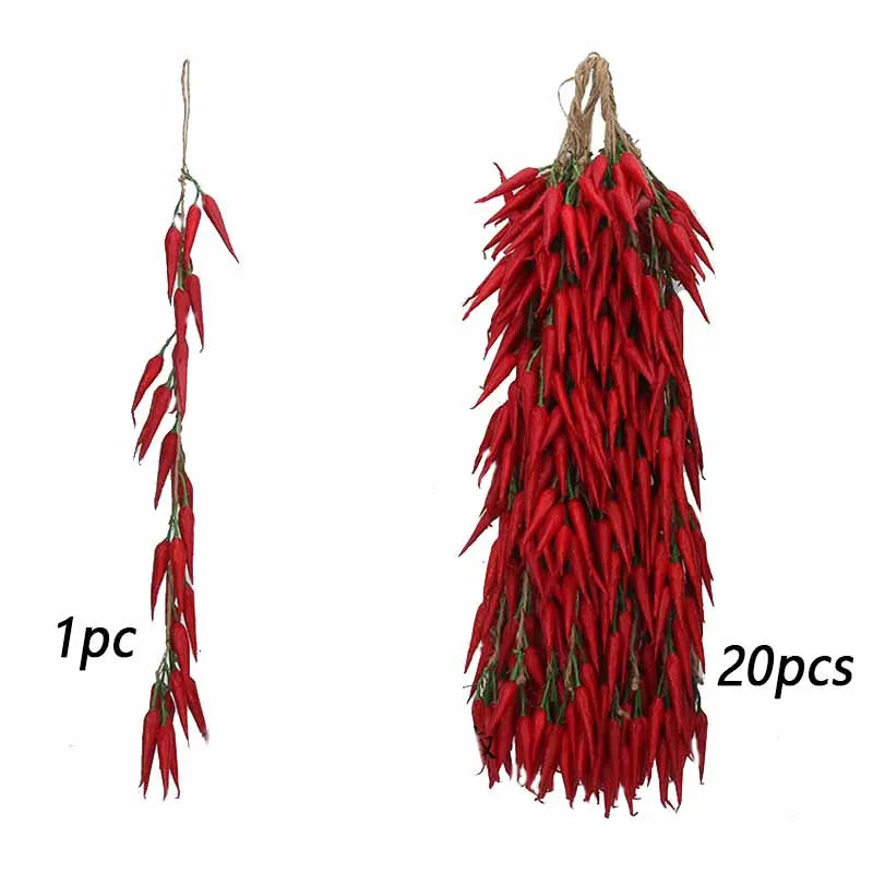 A bunch of bright red artificial chili peppers hanging from a twine string.