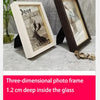 A wooden photo frame featuring a deer silhouette and landscape, displayed on a light surface.