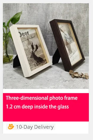 A wooden photo frame featuring a deer silhouette and landscape, displayed on a light surface.