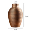 A terracotta-colored ceramic vase with horizontal ribbed texture and a tapered shape.