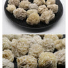 A pile of natural desert rose selenite stones in various shades of pale yellow and beige.