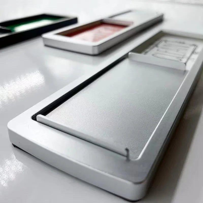A white dishwasher magnet sign is displayed on a white surface, next to another similar item.