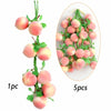 A sprig of artificial pink and yellow fruits used for decoration, shown individually and in a cluster.