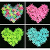 A collection of glow-in-the-dark star wall stickers in various shades of pink, green, and blue arranged in heart shapes.