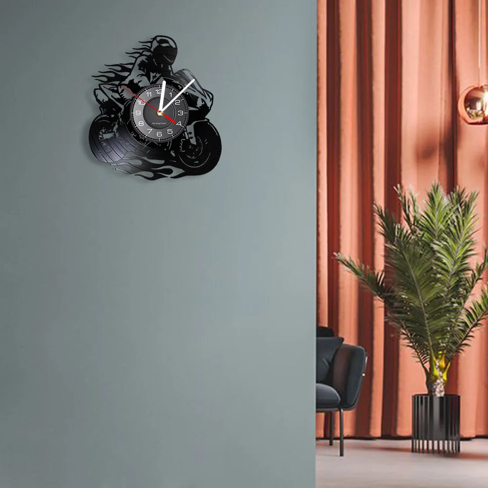 A black motorcycle rider vinyl record wall clock mounted on a gray wall.