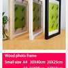 A set of wooden photo frames in various sizes, including A4 and A3, displayed on a light brown surface.