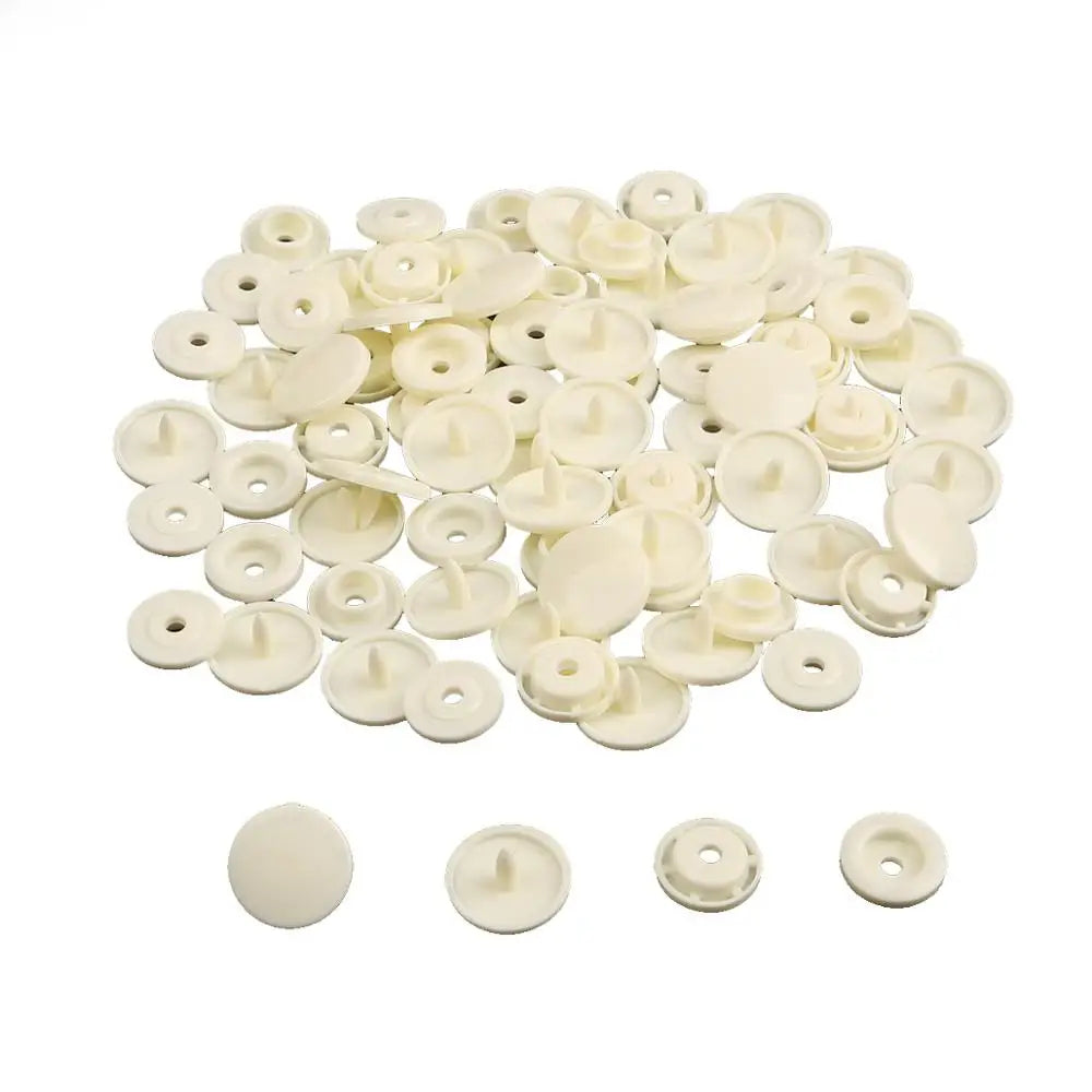 A pile of assorted white snap buttons measuring 12mm and 10.5mm for crafting.