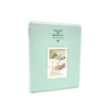 A light mint green compact photo album titled Pieces of Moment for instant film.