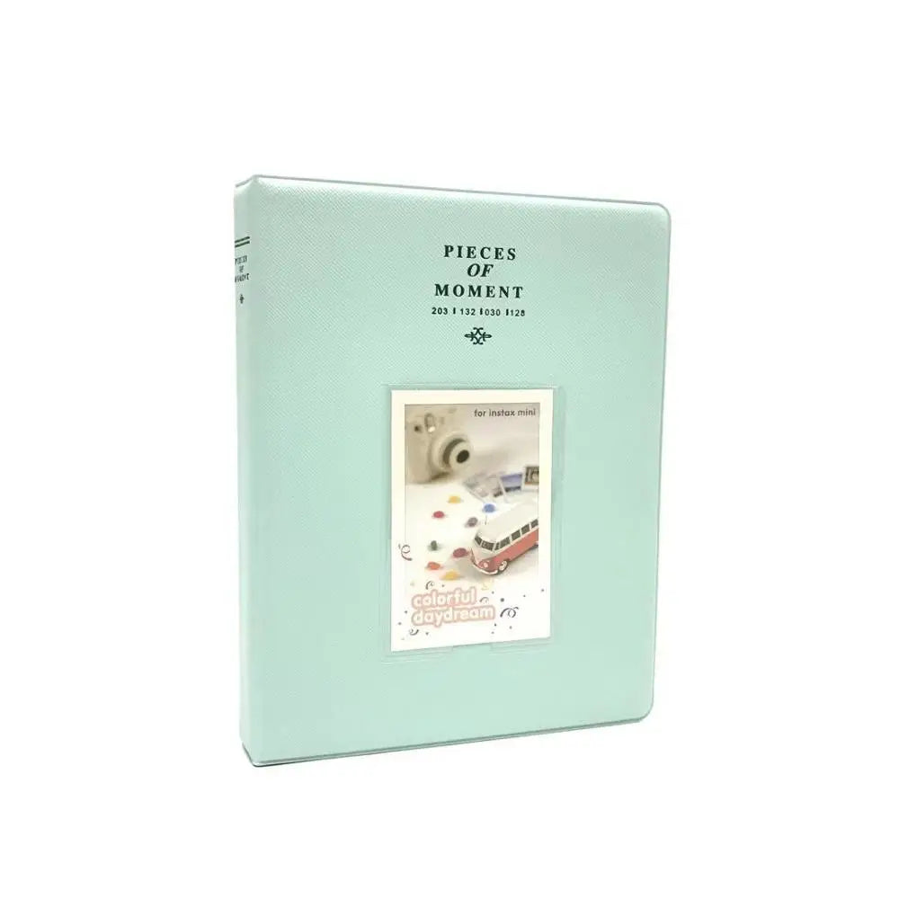 A light mint green compact photo album titled Pieces of Moment for instant film.